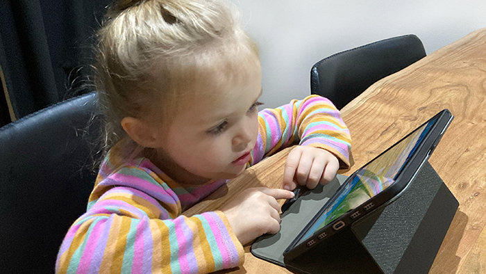 preschool girl doing a Reading Eggs learning activity on iPad.